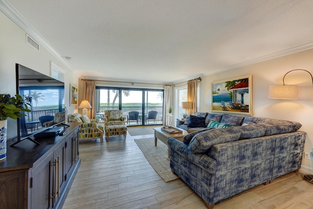 2641 NE Ocean Blvd Unit 106, Stuart, FL 34996 - living area featuring ornamental molding, light wood-style floors, and a textured ceiling