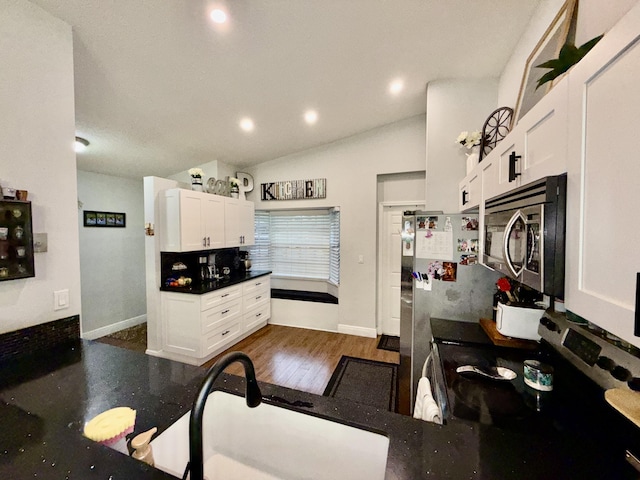 8421 SW 41st Ct, Davie, FL 33328 - kitchen with stainless steel appliances, white cabinetry, vaulted ceiling, baseboards, and recessed lighting
