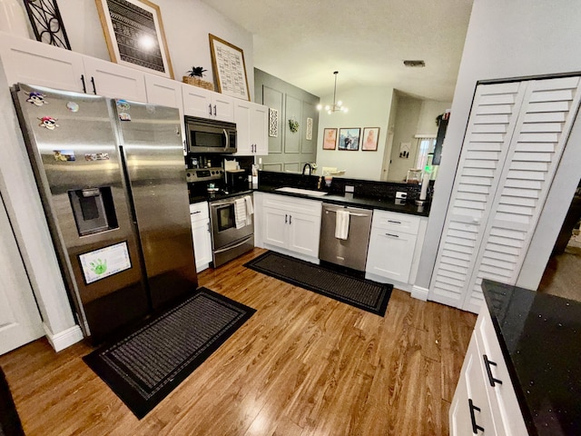 8421 SW 41st Ct, Davie, FL 33328 - kitchen featuring stainless steel appliances, a sink, dark countertops, light wood-type flooring, and lofted ceiling