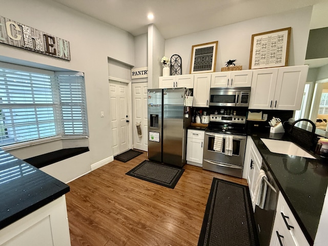8421 SW 41st Ct, Davie, FL 33328 - kitchen featuring stainless steel appliances, a sink, dark countertops, white cabinetry, and dark wood-style floors