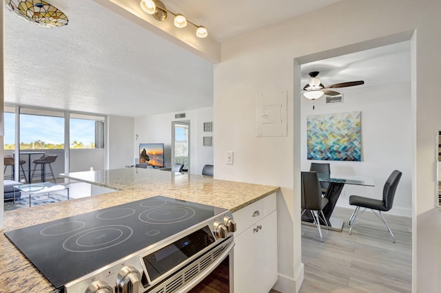 3640 N Ocean Dr Unit 427, Singer Island, FL 33404 - kitchen featuring electric range, light wood-style flooring, a ceiling fan, white cabinetry, and open floor plan