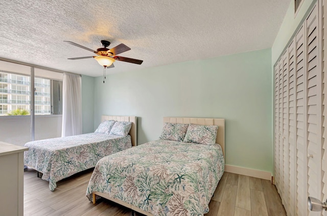 3640 N Ocean Dr Unit 427, Singer Island, FL 33404 - bedroom featuring wood finished floors, baseboards, a textured ceiling, and a ceiling fan