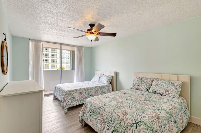3640 N Ocean Dr Unit 427, Singer Island, FL 33404 - bedroom featuring wood finished floors, a textured ceiling, ceiling fan, and baseboards