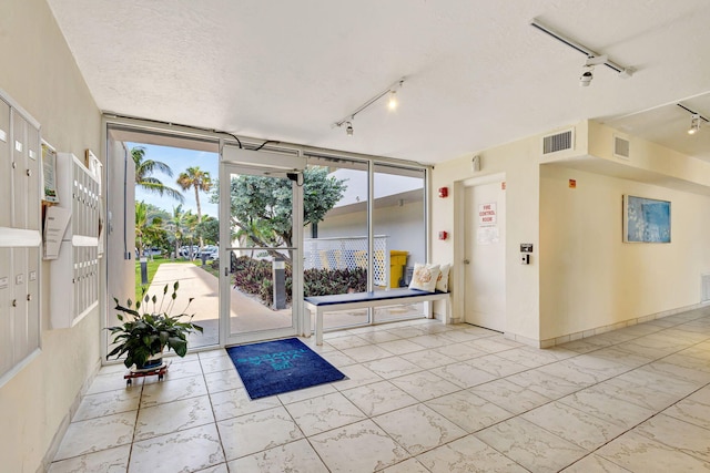 3640 N Ocean Dr Unit 427, Singer Island, FL 33404 - interior space with track lighting, a textured ceiling, baseboards, and expansive windows