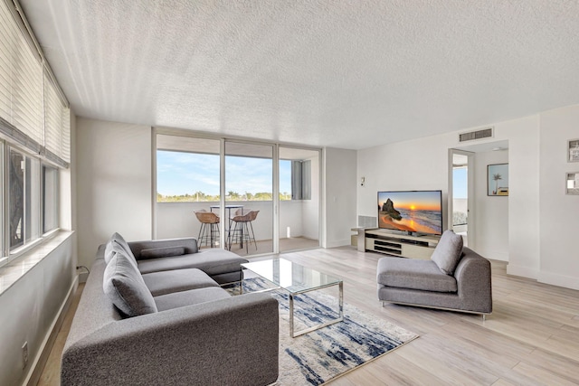3640 N Ocean Dr Unit 427, Singer Island, FL 33404 - living area featuring a textured ceiling, light wood-style flooring, and baseboards