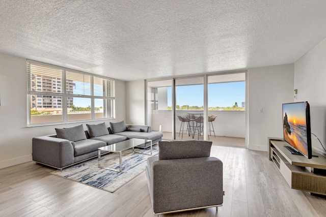 3640 N Ocean Dr Unit 427, Singer Island, FL 33404 - living area with light wood-type flooring, baseboards, and a textured ceiling