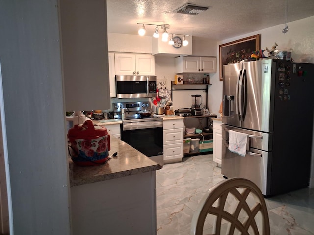 2506 Oleander Blvd, Fort Pierce, FL 34982 - kitchen with stainless steel appliances, white cabinetry, a textured ceiling, and light marble finish flooring