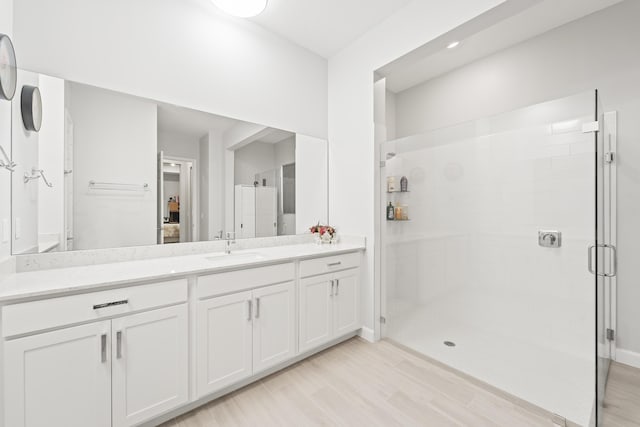19404 Broad Shore Walk, Loxahatchee, FL 33470 - ensuite bathroom featuring vanity, a stall shower, wood finished floors, and baseboards