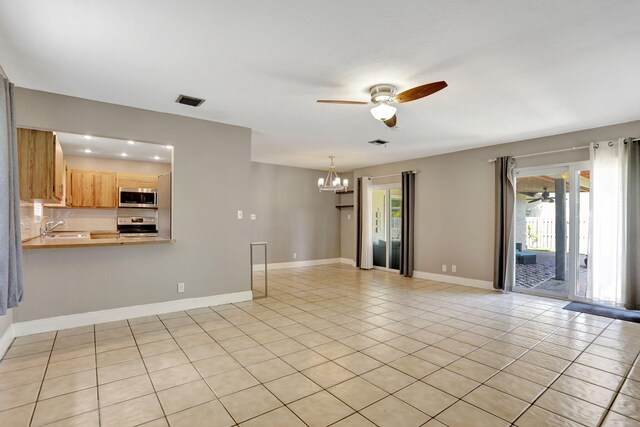 9062 NW 20th Mnr, Coral Springs, FL 33071 - unfurnished living room featuring a ceiling fan, a chandelier, a sink, light tile patterned floors, and baseboards