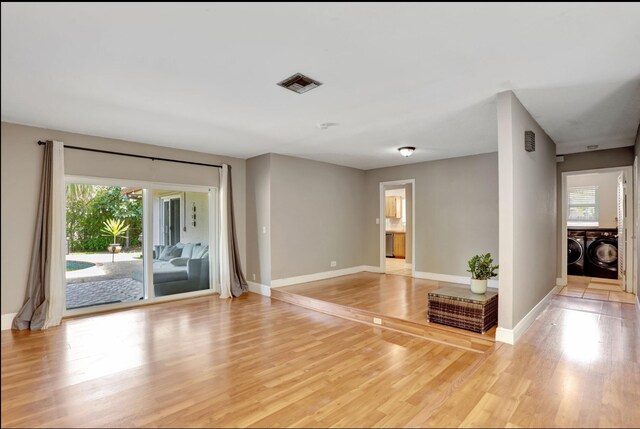 9062 NW 20th Mnr, Coral Springs, FL 33071 - empty room featuring independent washer and dryer, baseboards, and light wood finished floors