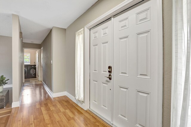 9062 NW 20th Mnr, Coral Springs, FL 33071 - entrance foyer with washing machine and clothes dryer, light wood-style floors, and baseboards
