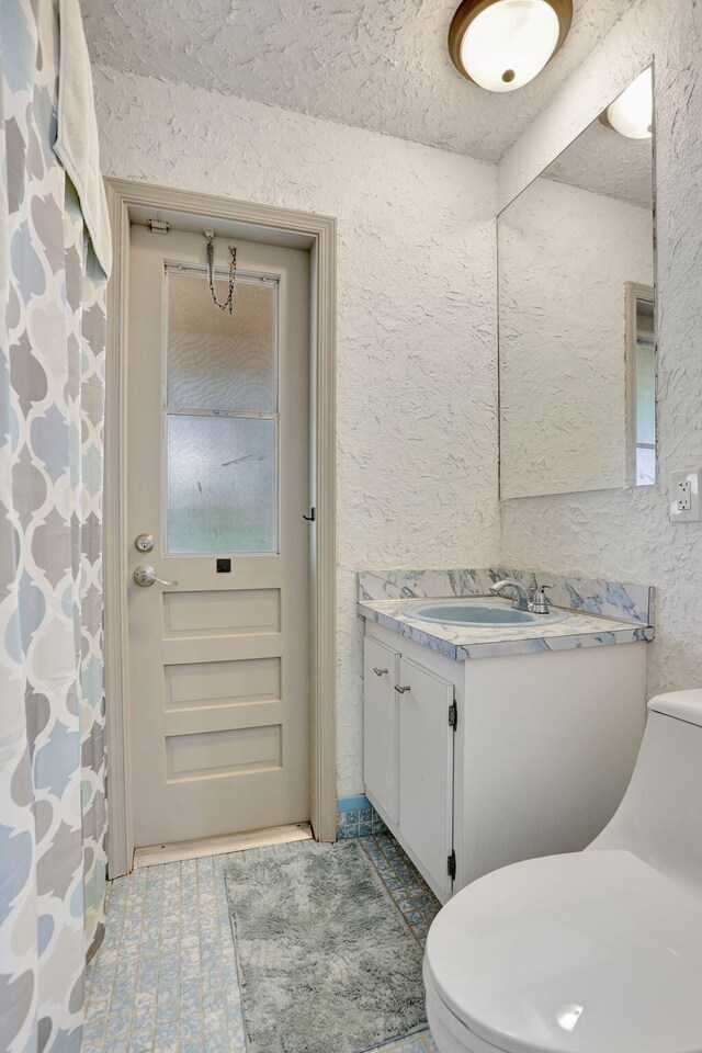 9062 NW 20th Mnr, Coral Springs, FL 33071 - bathroom with toilet, a textured wall, and vanity