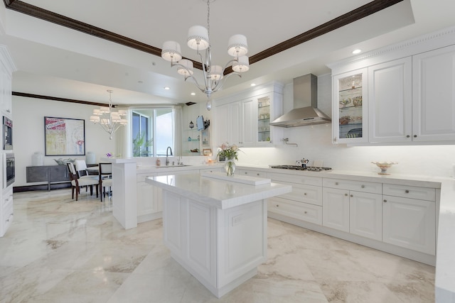 5050 N Ocean Dr Unit 1701, Singer Island, FL 33404 - kitchen featuring wall chimney exhaust hood, a chandelier, ornamental molding, a sink, and a peninsula
