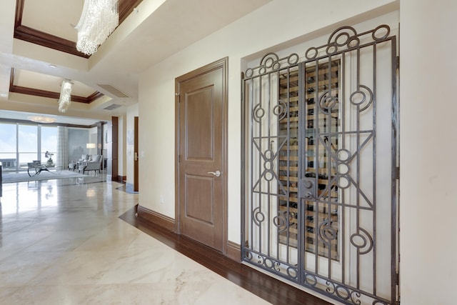 5050 N Ocean Dr Unit 1701, Singer Island, FL 33404 - entryway featuring ornamental molding, marble finish flooring, a tray ceiling, baseboards, and a chandelier