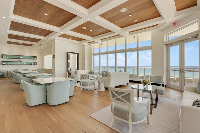 5050 N Ocean Dr Unit 1701, Singer Island, FL 33404 - living area featuring coffered ceiling, a water view, light wood-style floors, beam ceiling, and plenty of natural light