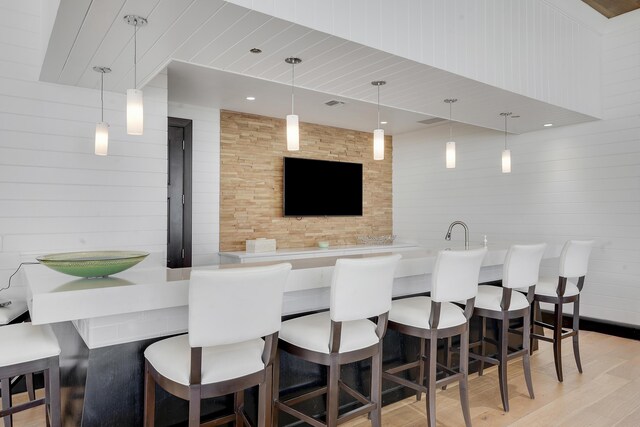 5050 N Ocean Dr Unit 1701, Singer Island, FL 33404 - indoor wet bar featuring light wood-type flooring, pendant lighting, and wood walls