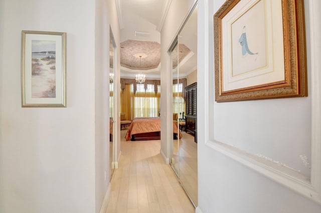 8127 Playa Del Sur Blvd, Lake Worth, FL 33467 - hallway with crown molding, a chandelier, a raised ceiling, light wood-style floors, and baseboards