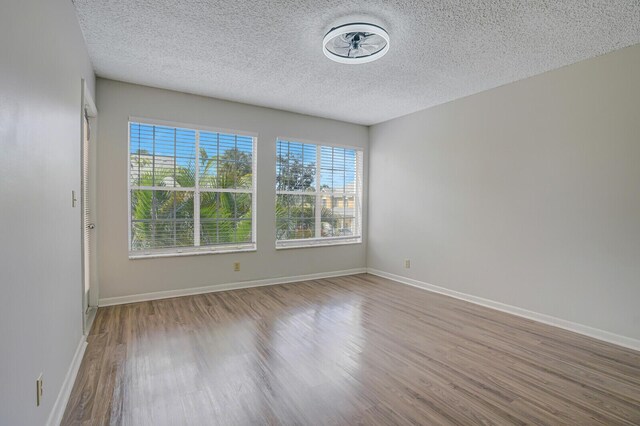 6315 La Costa Dr Unit G, Boca Raton, FL 33433 - empty room with wood finished floors, a textured ceiling, and baseboards