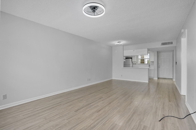 6315 La Costa Dr Unit G, Boca Raton, FL 33433 - unfurnished living room featuring a textured ceiling, light wood-type flooring, baseboards, and ceiling fan