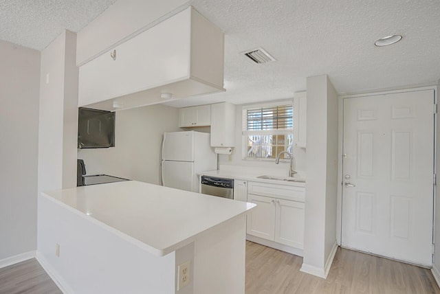 6315 La Costa Dr Unit G, Boca Raton, FL 33433 - kitchen with freestanding refrigerator, a textured ceiling, a sink, dishwasher, and light wood-style flooring
