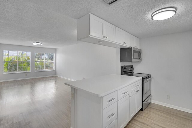 6315 La Costa Dr Unit G, Boca Raton, FL 33433 - kitchen featuring stainless steel appliances, a textured ceiling, light wood-style floors, open floor plan, and light countertops