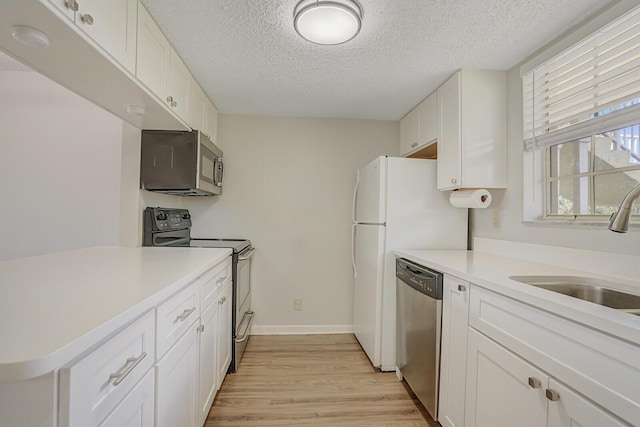 6315 La Costa Dr Unit G, Boca Raton, FL 33433 - kitchen featuring stainless steel appliances, light wood-style flooring, a textured ceiling, white cabinets, and a sink