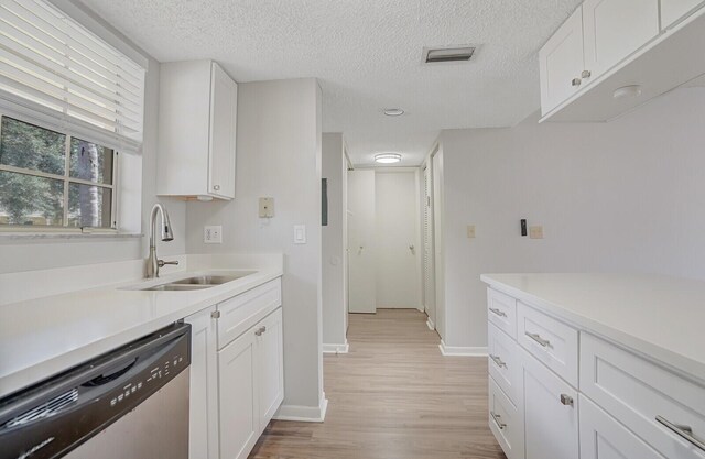 6315 La Costa Dr Unit G, Boca Raton, FL 33433 - kitchen featuring stainless steel dishwasher, a sink, light wood-style floors, light countertops, and white cabinetry