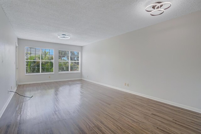 6315 La Costa Dr Unit G, Boca Raton, FL 33433 - spare room with a textured ceiling, wood finished floors, and baseboards