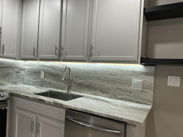 267 Flanders F, Delray Beach, FL 33484 - kitchen with stainless steel dishwasher, light stone countertops, and white cabinetry