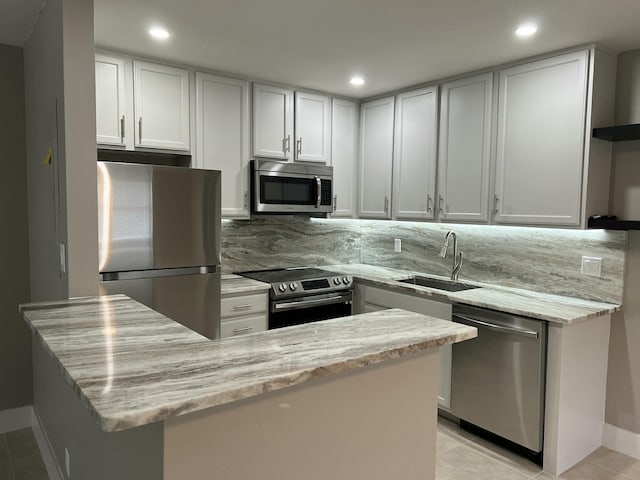 267 Flanders F, Delray Beach, FL 33484 - kitchen featuring appliances with stainless steel finishes, open shelves, light stone counters, recessed lighting, and white cabinets