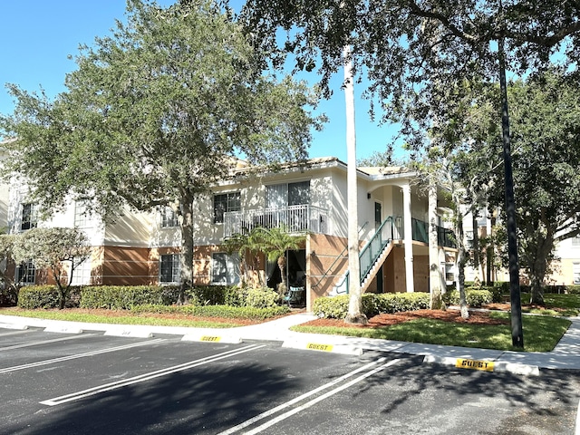 5205 Myrtlewood Cir E, Palm Beach Gardens, FL 33418 - view of building exterior with uncovered parking and stairway
