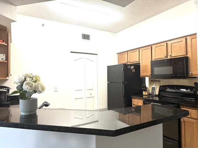 5205 Myrtlewood Cir E, Palm Beach Gardens, FL 33418 - kitchen featuring black appliances, a textured ceiling, brown cabinets, and dark stone countertops