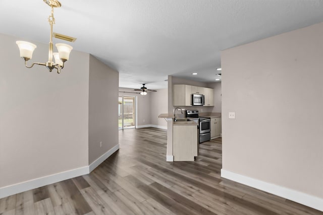 1413 Amaryllis Ln, West Palm Beach, FL 33415 - kitchen featuring appliances with stainless steel finishes, a sink, baseboards, open floor plan, and dark wood-style flooring