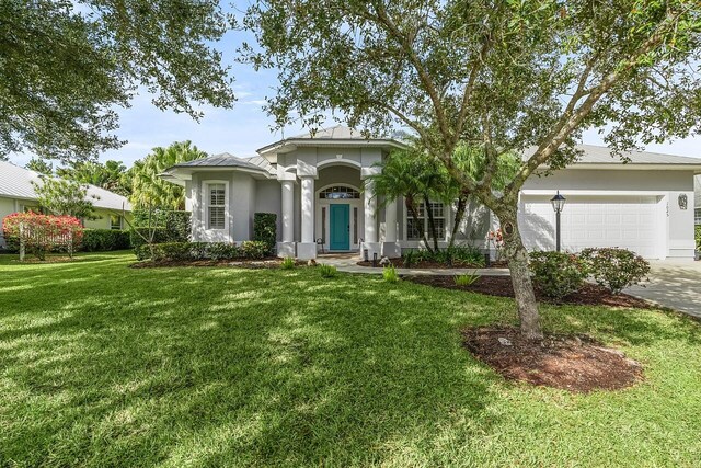 1025 Whitetail Ave SW, Vero Beach, FL 32968 - view of front of property with a front yard, an attached garage, driveway, and stucco siding