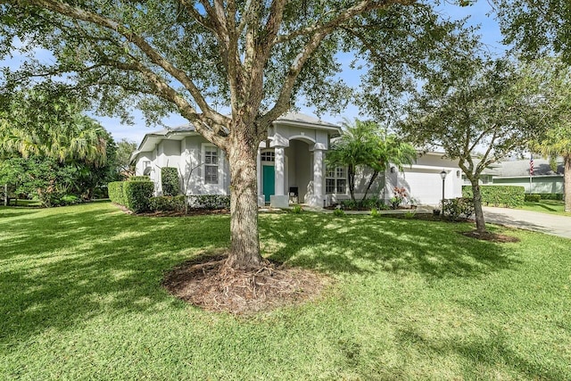 1025 Whitetail Ave SW, Vero Beach, FL 32968 - ranch-style house with a garage, a front yard, driveway, and stucco siding