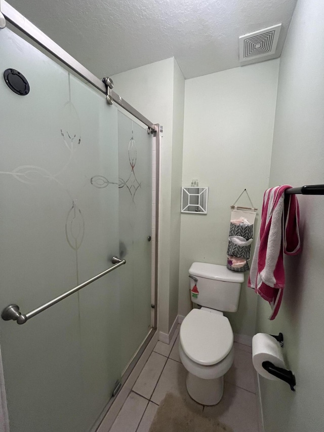 991 SE Bywood Ave, Port Saint Lucie, FL 34983 - full bathroom with a shower stall, toilet, tile patterned flooring, and a textured ceiling