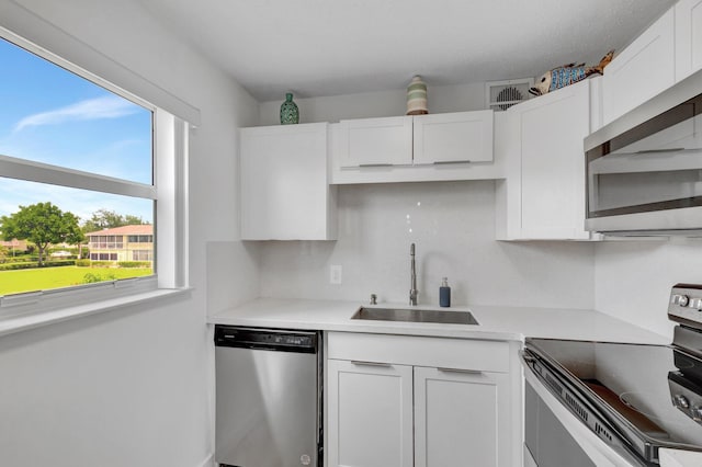 229 Chatham K, West Palm Beach, FL 33417 - kitchen with stainless steel appliances, a sink, white cabinets, and light countertops