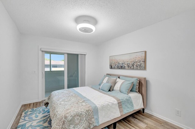 229 Chatham K, West Palm Beach, FL 33417 - bedroom with wood finished floors, baseboards, a textured ceiling, and access to outside