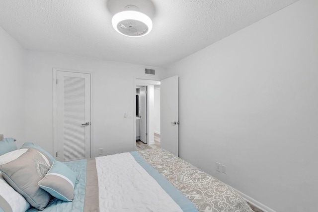 229 Chatham K, West Palm Beach, FL 33417 - bedroom featuring a textured ceiling and a closet