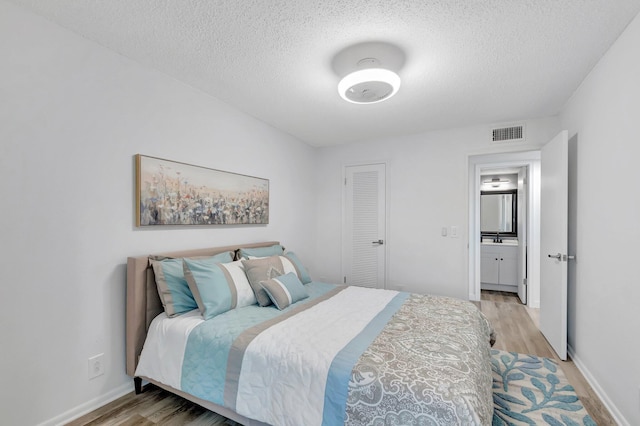 229 Chatham K, West Palm Beach, FL 33417 - bedroom featuring light wood finished floors, a textured ceiling, baseboards, and a sink