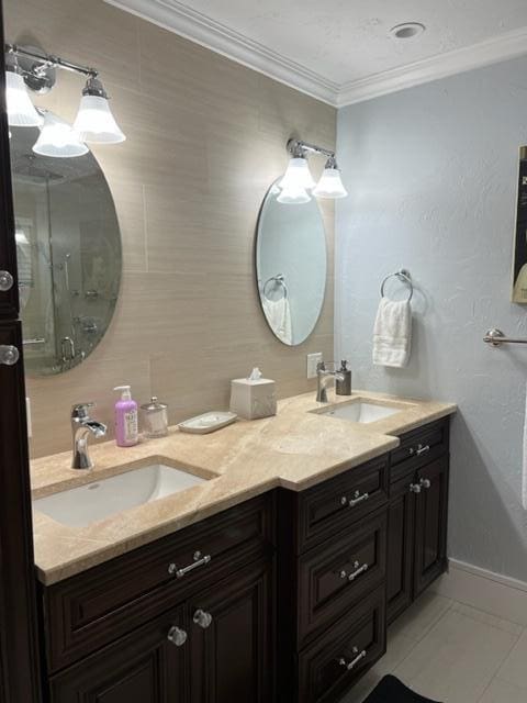 501 SE 13th Ct, Pompano Beach, FL 33060 - bathroom featuring crown molding, double vanity, tile patterned flooring, baseboards, and tasteful backsplash