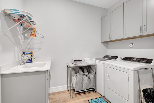 5322 Yellow Water Lily Ct, Lake Worth, FL 33467 - laundry room with cabinet space, washing machine and clothes dryer, light wood-style floors, and baseboards