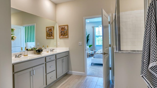 1553 SE Crosswood Way, Port Saint Lucie, FL 34984 - full bathroom with double vanity, curtained shower, wood finished floors, ensuite bathroom, and baseboards