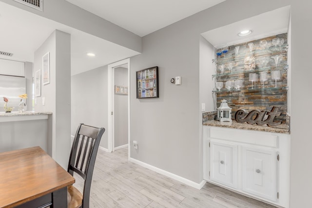 390 NE Edgewater Dr Unit 302, Stuart, FL 34996 - dining space featuring baseboards, a bar, light wood finished floors, and recessed lighting