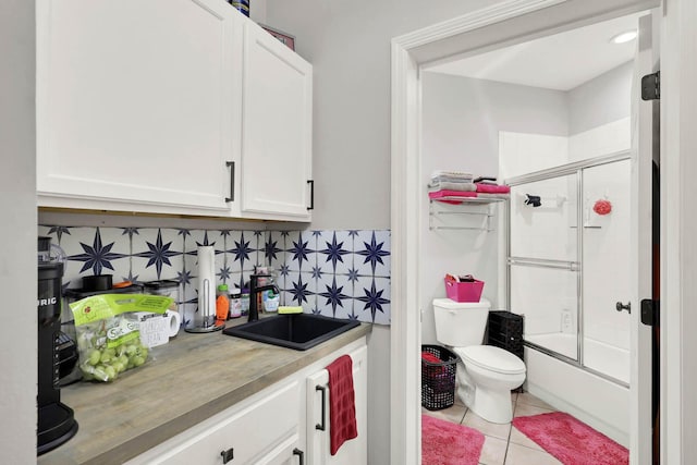 9927 Perfect Dr Unit 108, Port Saint Lucie, FL 34986 - bar featuring a sink, tile patterned flooring, and backsplash