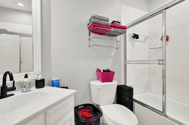 9927 Perfect Dr Unit 108, Port Saint Lucie, FL 34986 - bathroom featuring vanity, toilet, and bath / shower combo with glass door