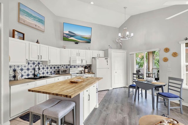 9927 Perfect Dr Unit 108, Port Saint Lucie, FL 34986 - kitchen with white appliances, butcher block counters, high vaulted ceiling, a sink, and decorative backsplash