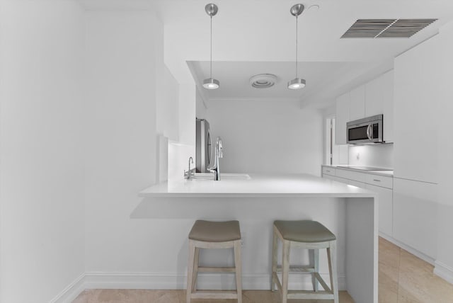 550 SE Mizner Blvd Unit B206, Boca Raton, FL 33432 - kitchen featuring stainless steel appliances, modern cabinets, a breakfast bar area, white cabinets, and a peninsula