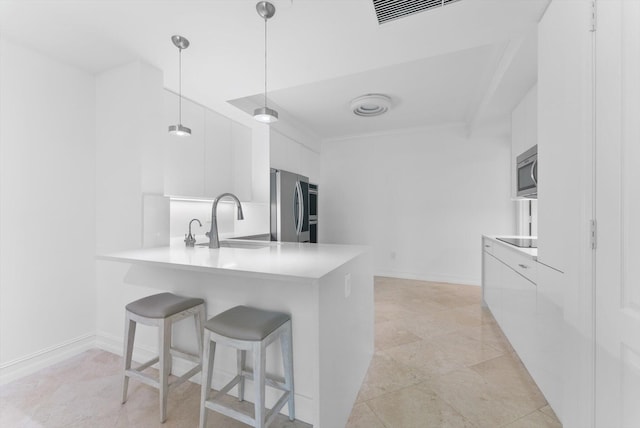 550 SE Mizner Blvd Unit B206, Boca Raton, FL 33432 - kitchen featuring modern cabinets, appliances with stainless steel finishes, a sink, white cabinets, and a kitchen breakfast bar