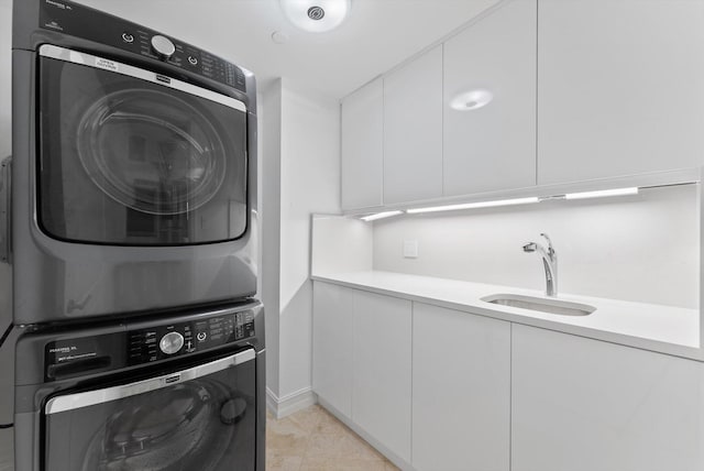 550 SE Mizner Blvd Unit B206, Boca Raton, FL 33432 - laundry area with stacked washing machine and dryer, cabinet space, and baseboards